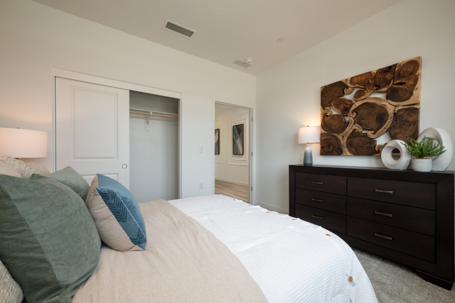 A bedroom with a bed and a dresser.