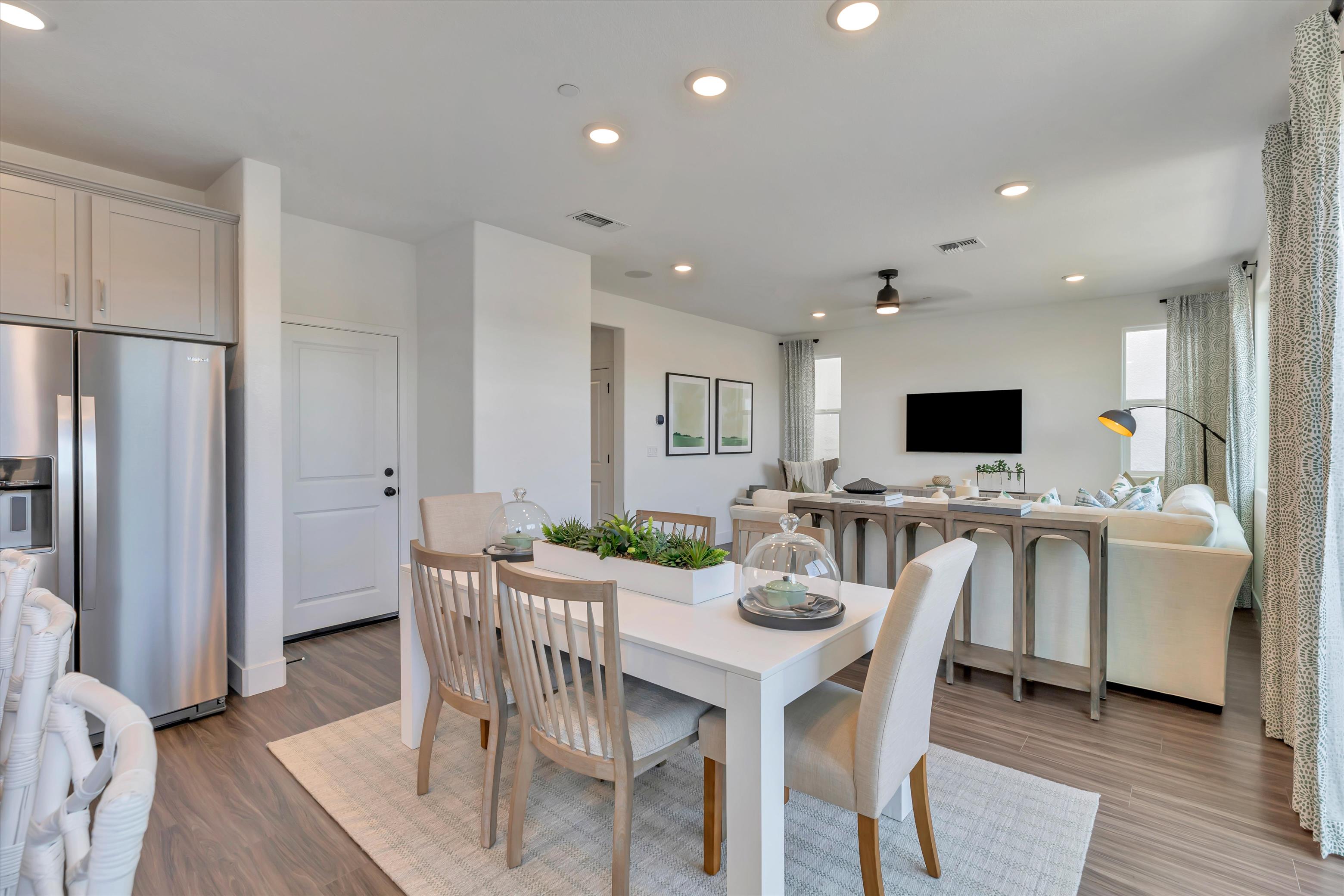 A kitchen with a dining table and chairs.
