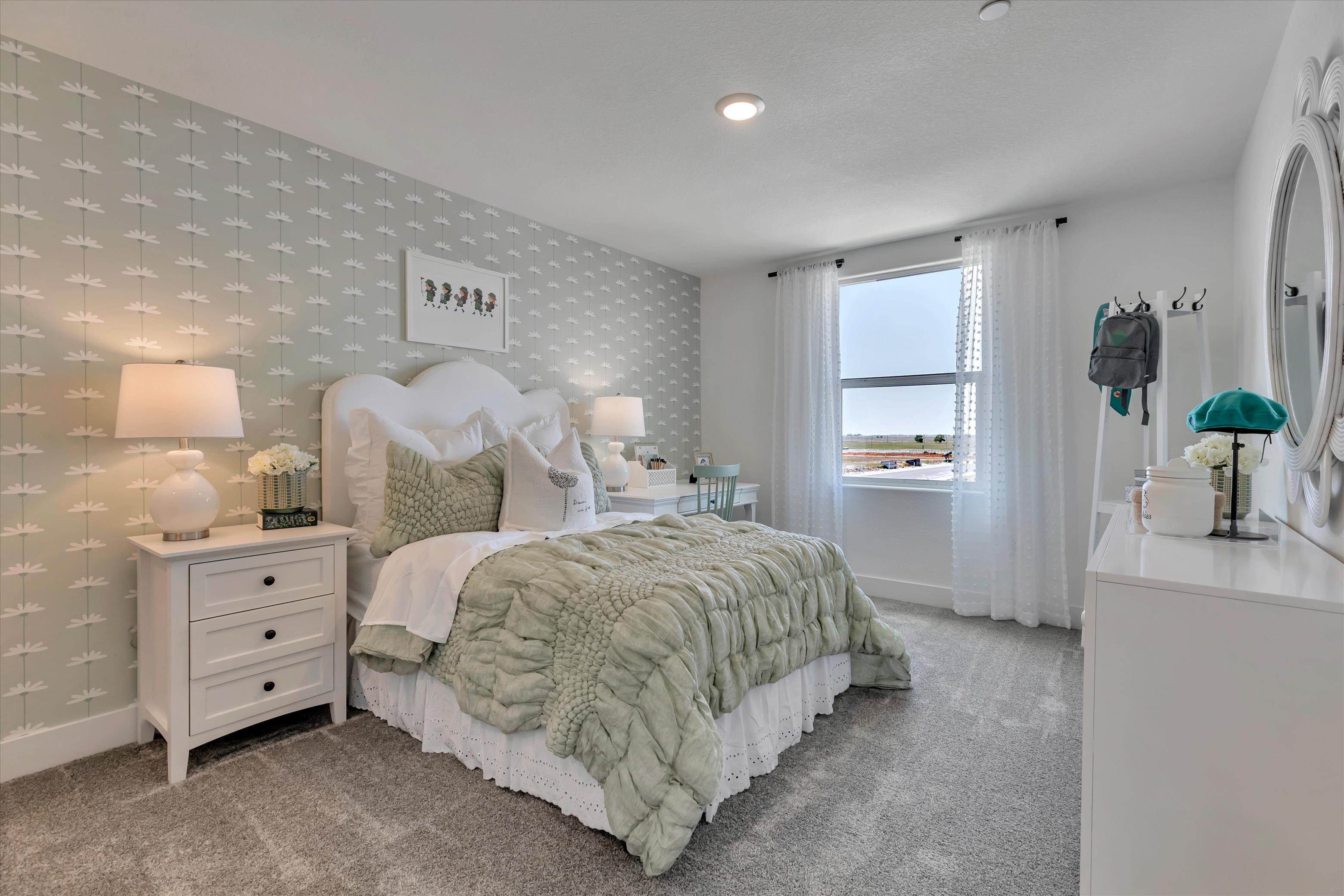 A bedroom with a bed and lamps.