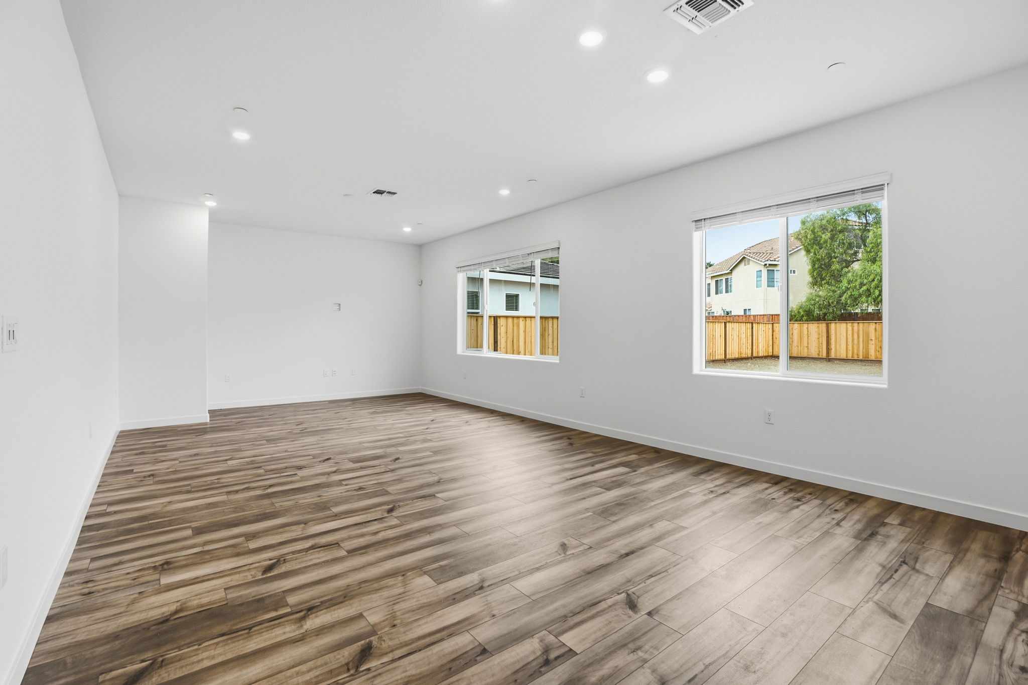 A room with a wood floor and a wood floor with a window.