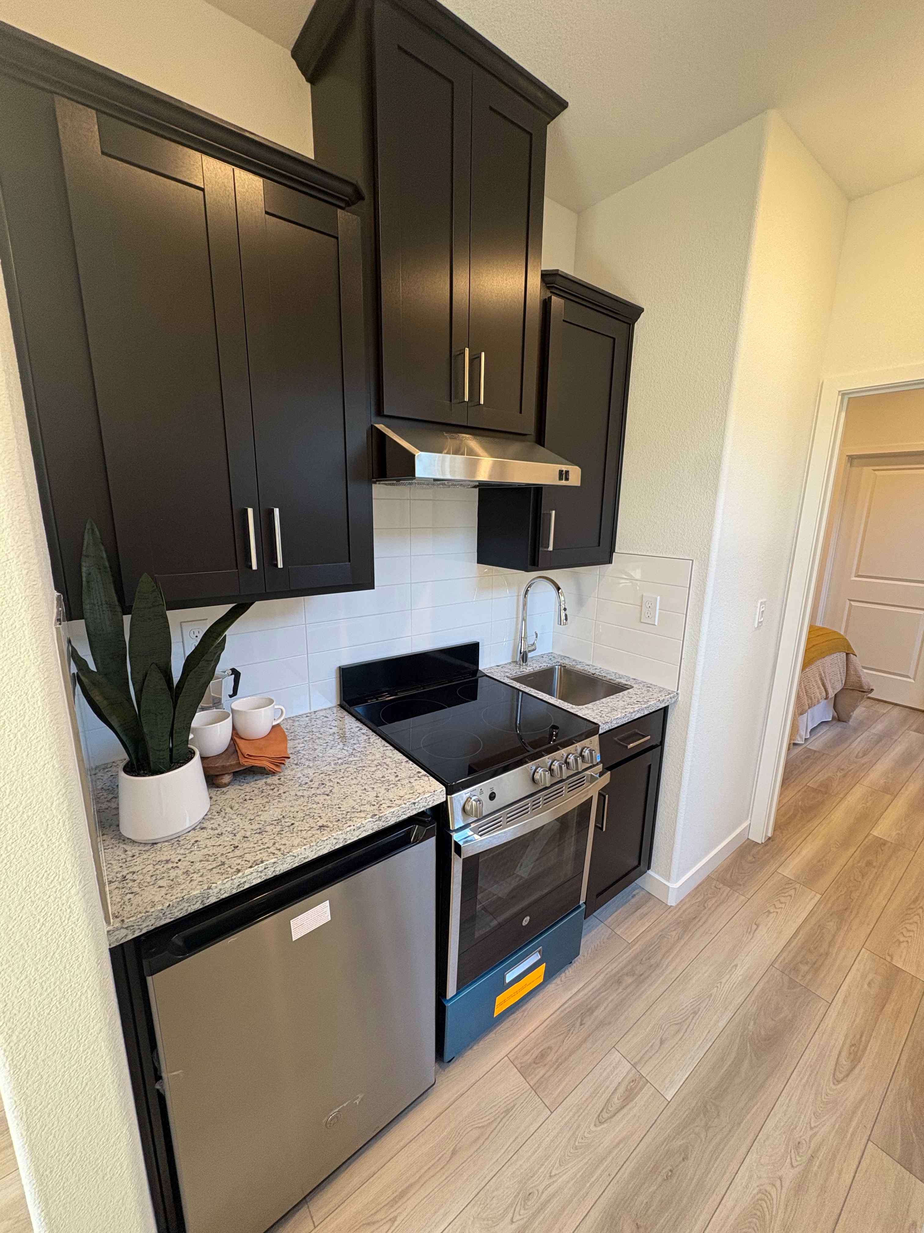A kitchen with black cabinets.