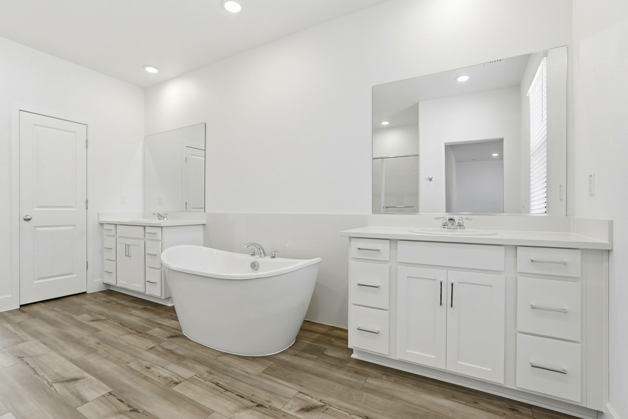 A bathroom with white cabinets.