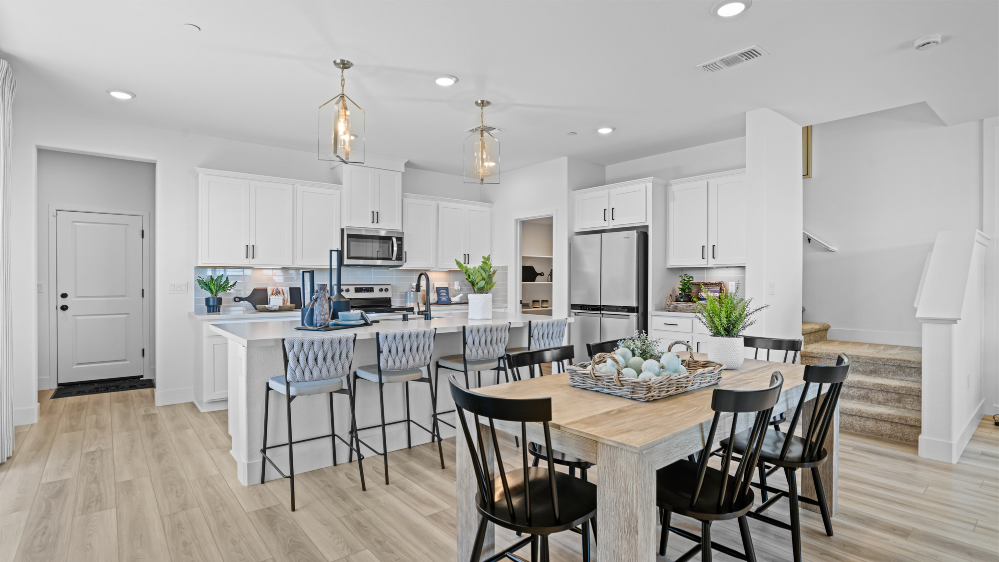 A kitchen with a dining table and chairs.