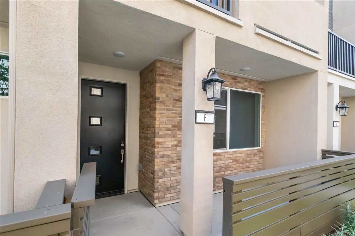 A building with a wood door and a bench in the front.