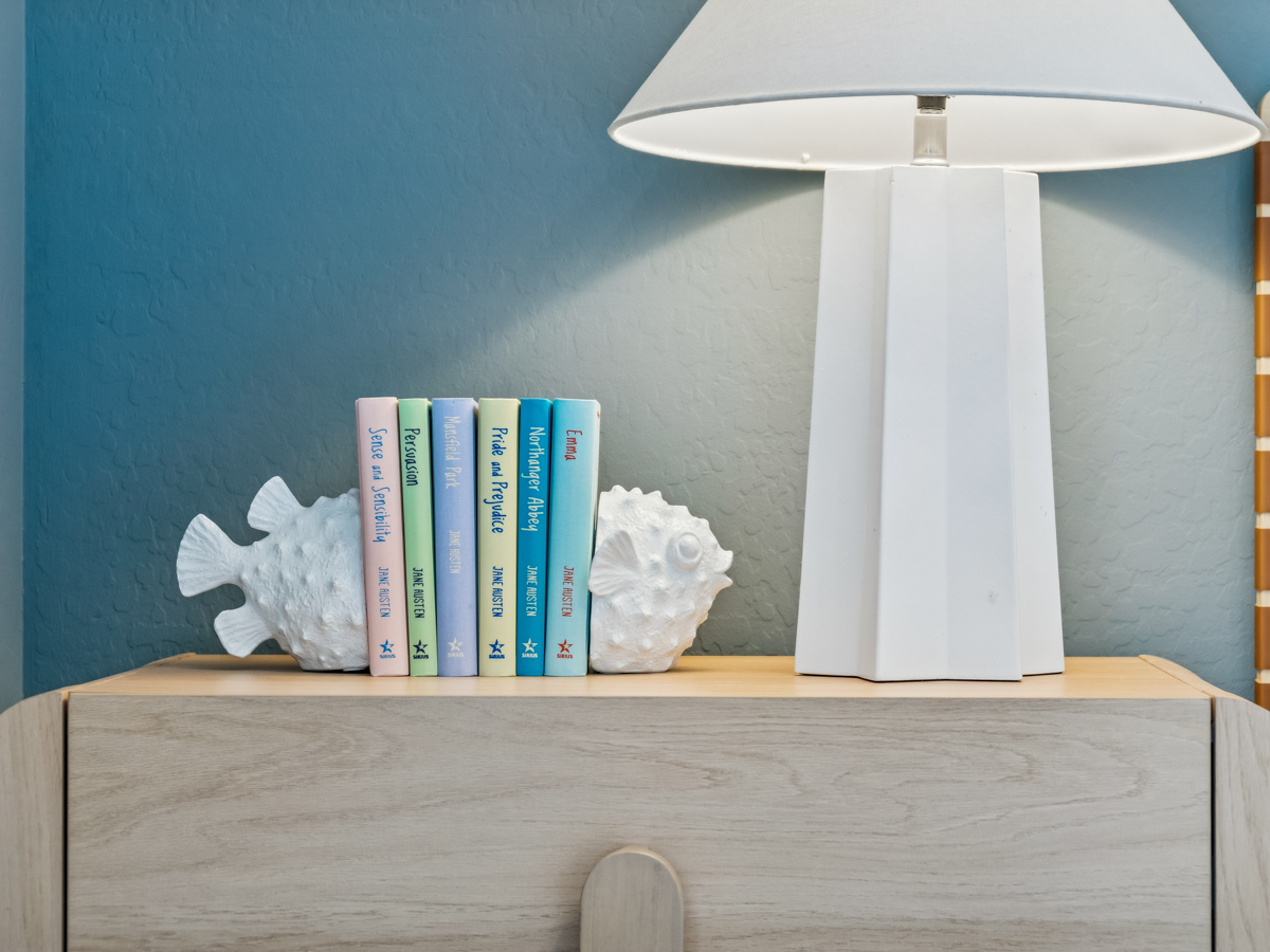 A lamp and books on a shelf.