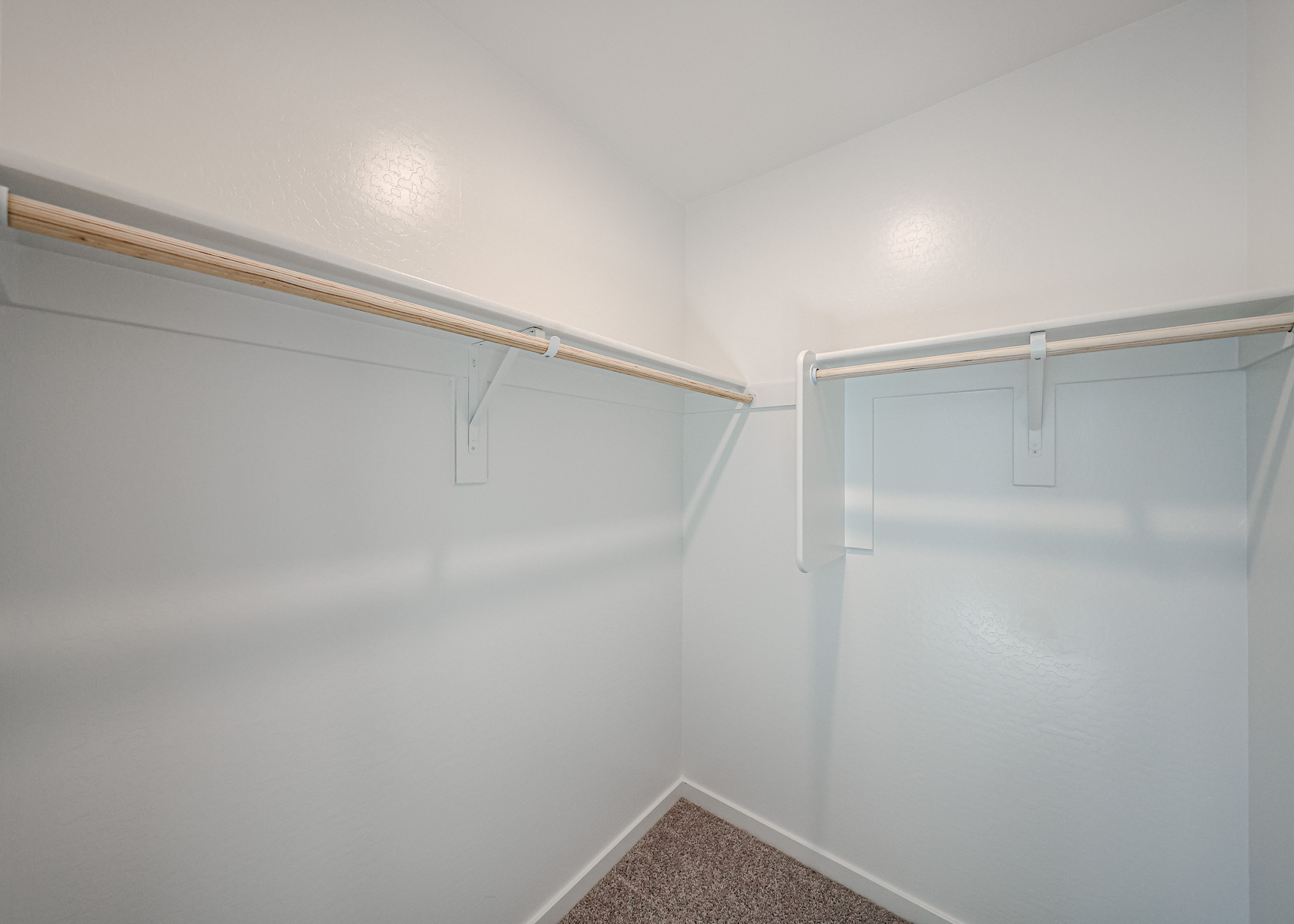 A white wall with a metal bar.