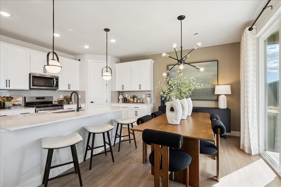 A kitchen with a dining table and chairs.