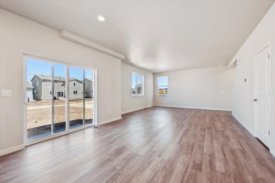 A room with a wood floor and a wood floor with a large window.