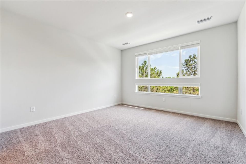 A room with a window and a carpet.