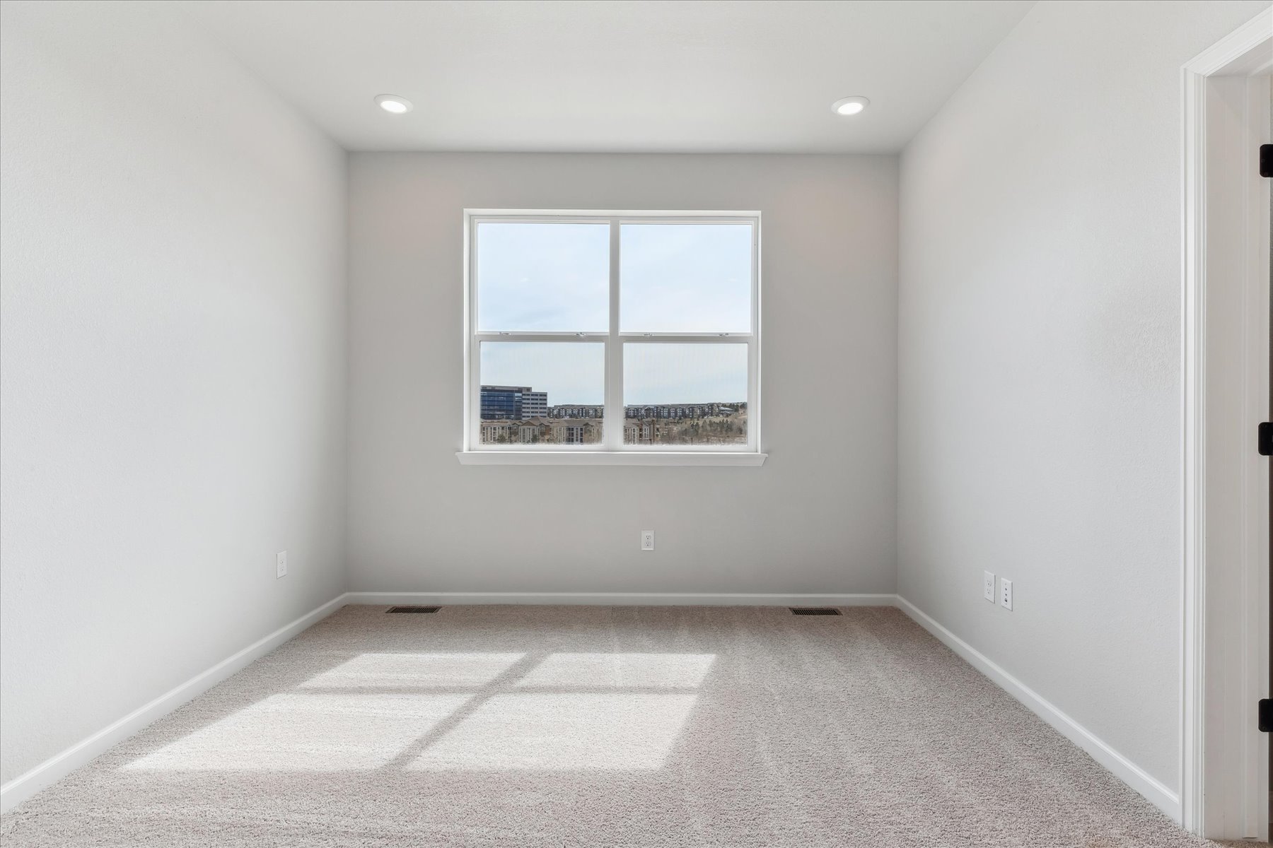 A room with a window and a rug.