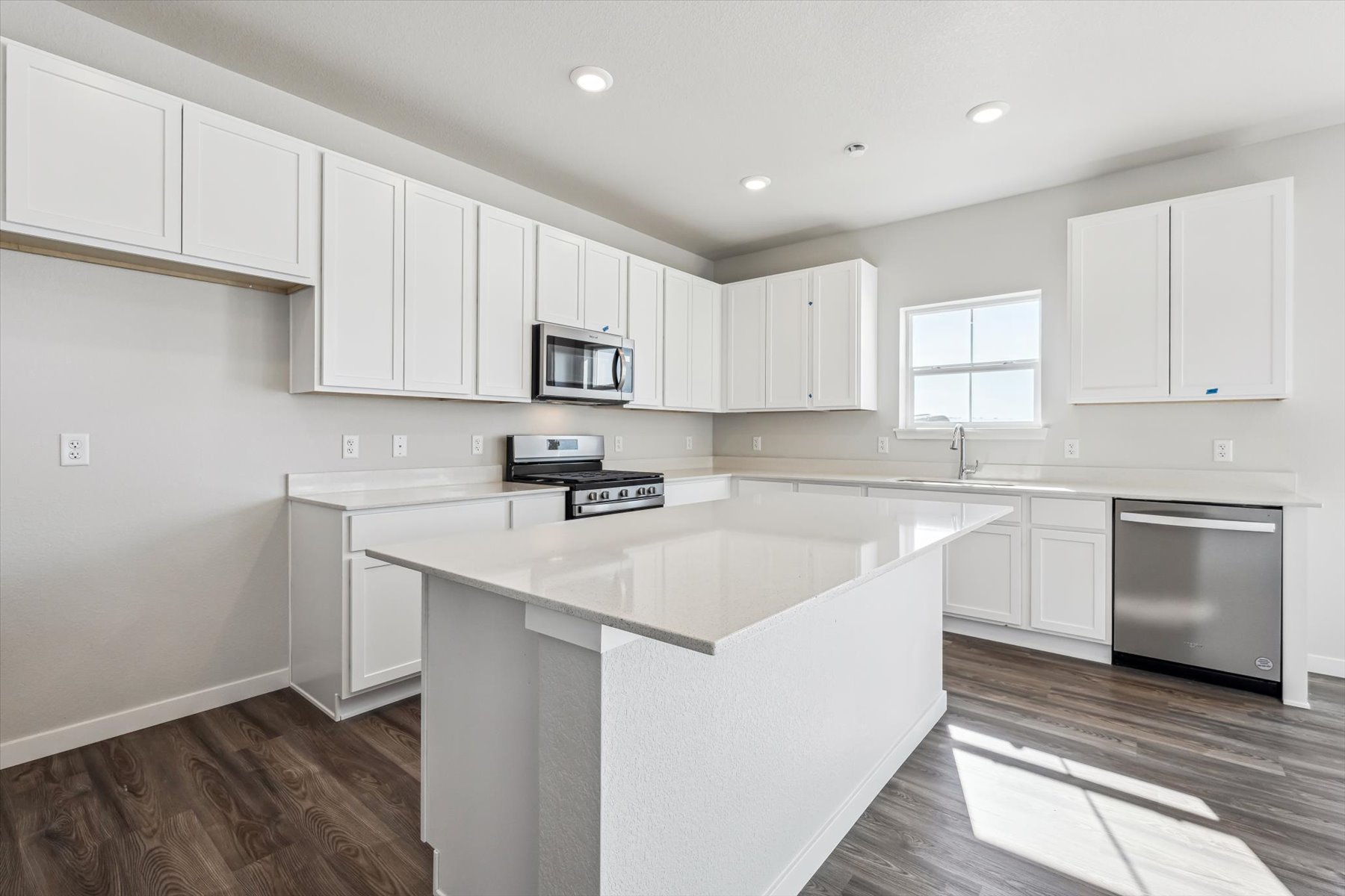A kitchen with white cabinets.
