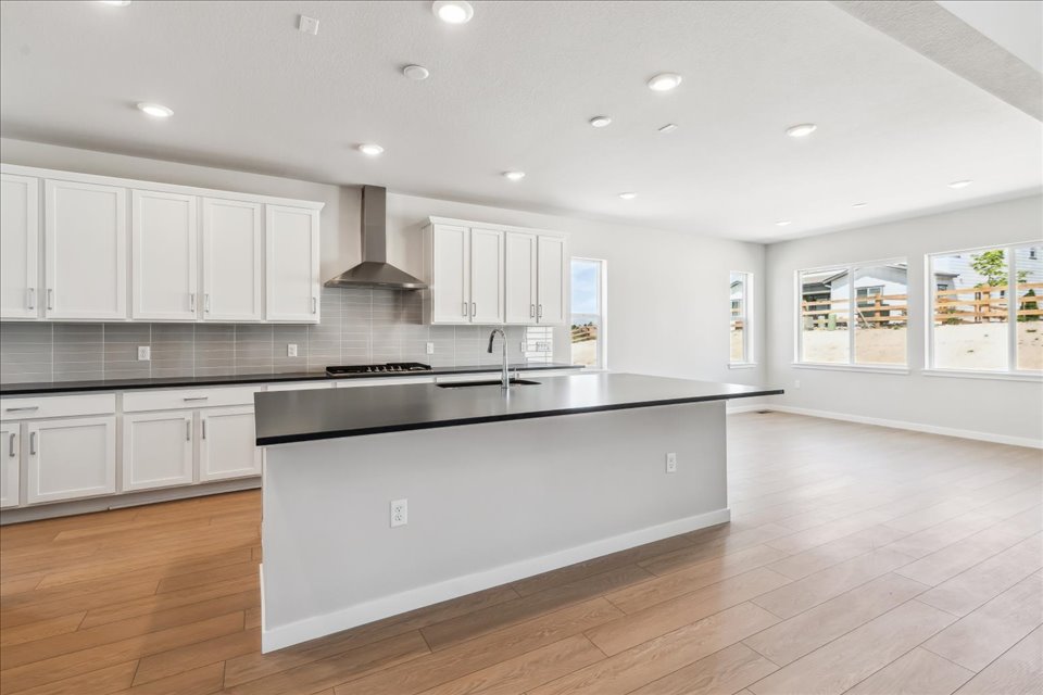 A kitchen with white cabinets.
