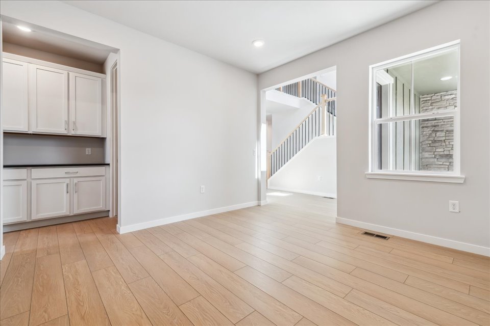 A room with white walls and wood floors.