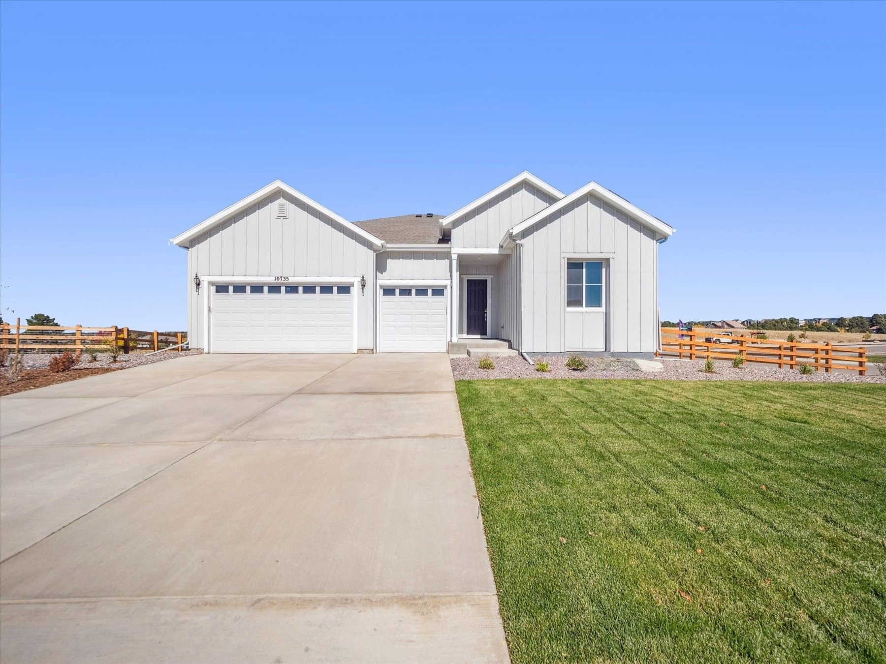 A white house with a green lawn.