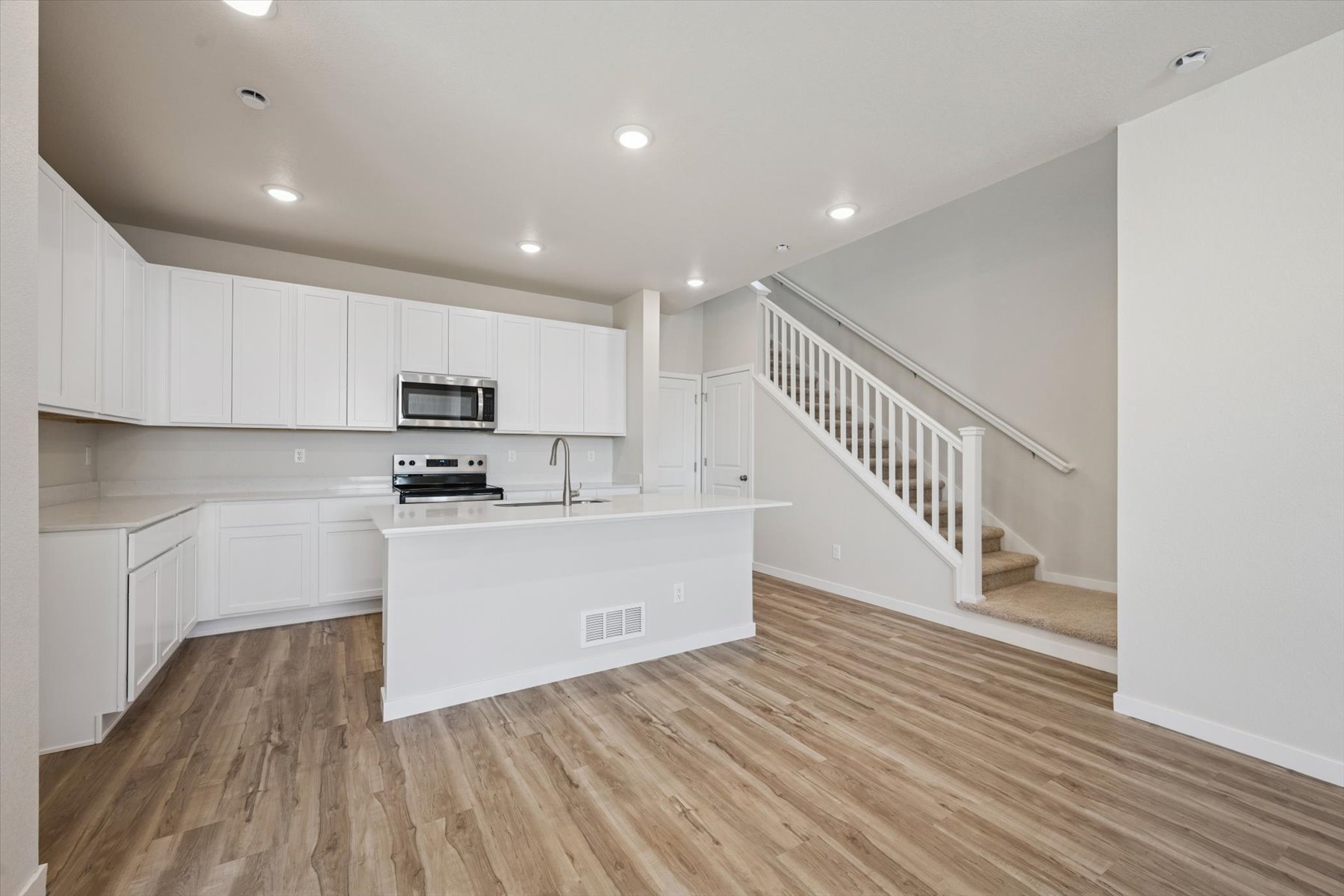 A kitchen with white cabinets.