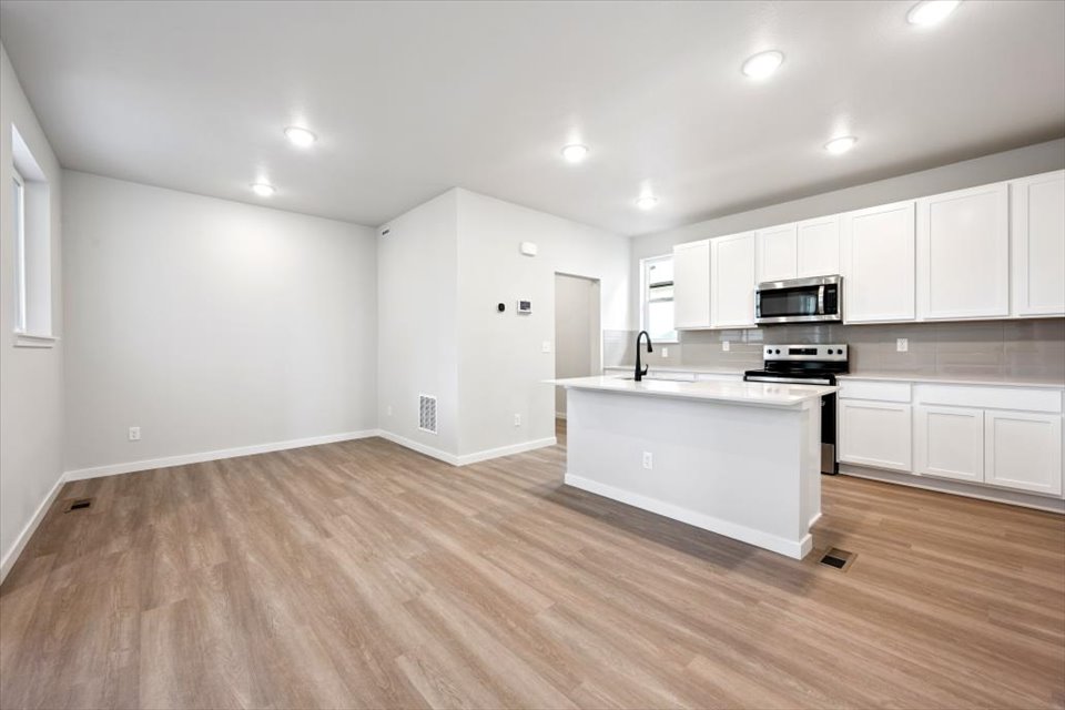A kitchen with white cabinets.