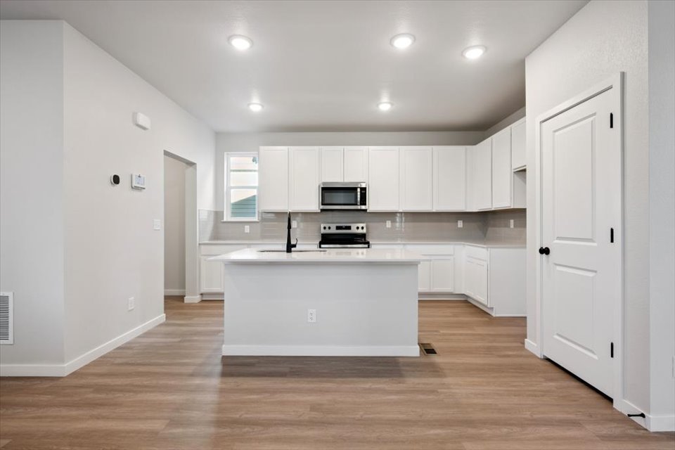 A kitchen with white cabinets.
