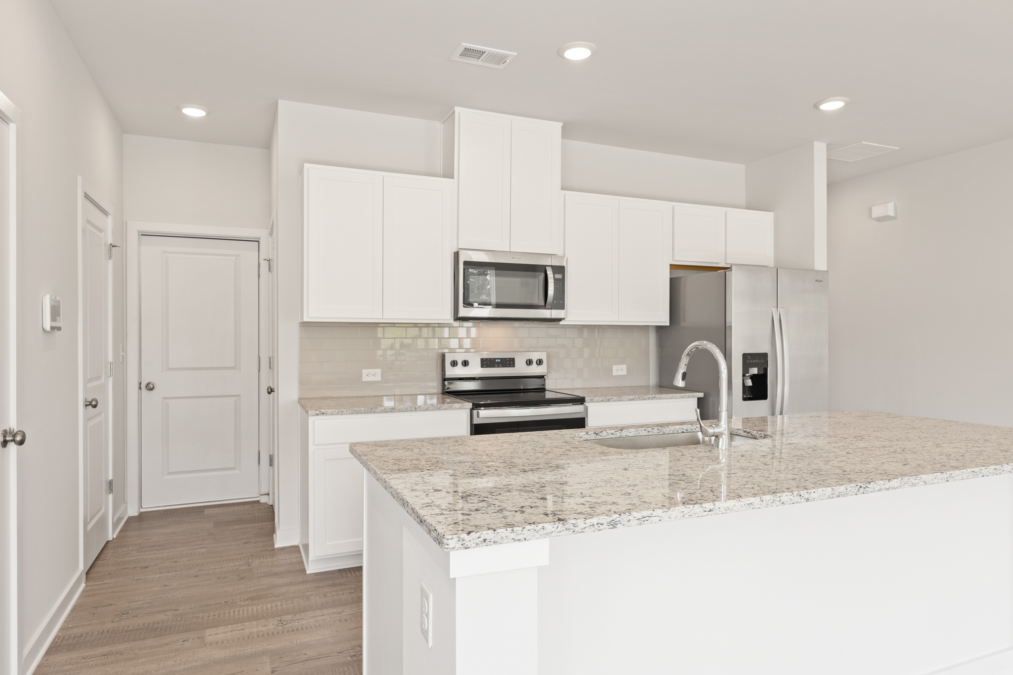 A kitchen with white cabinets.