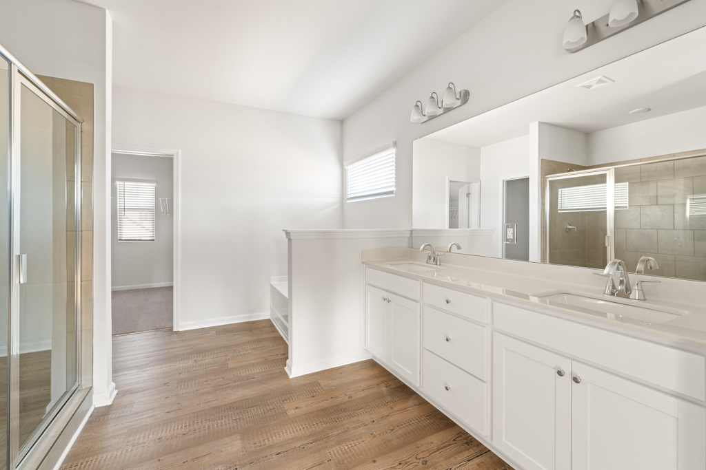 A bathroom with white cabinets.