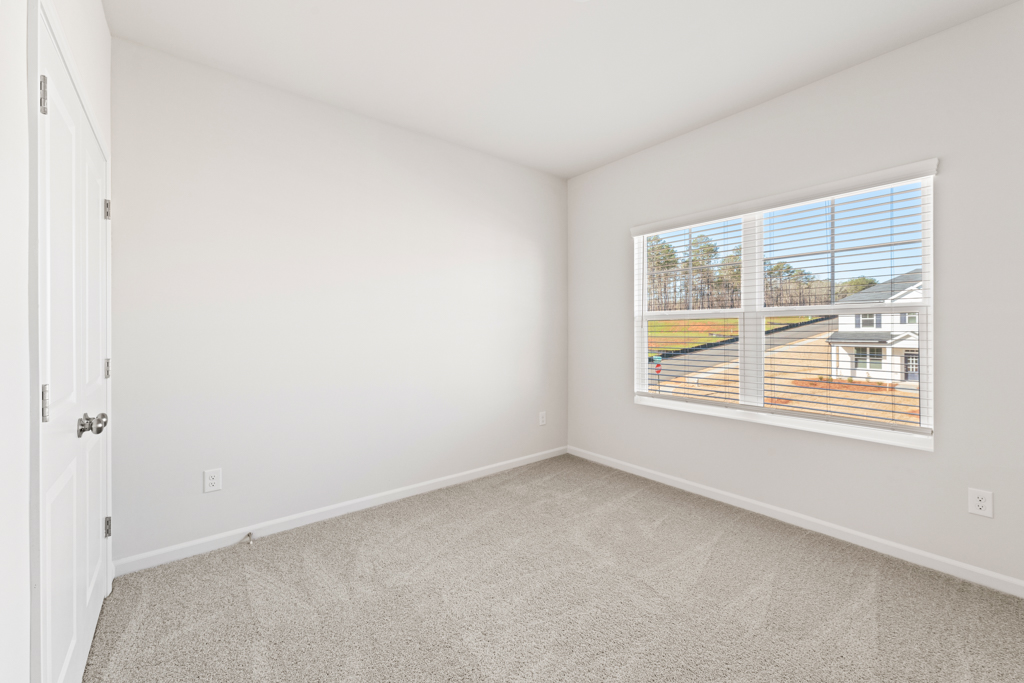 A room with a window and a carpet.