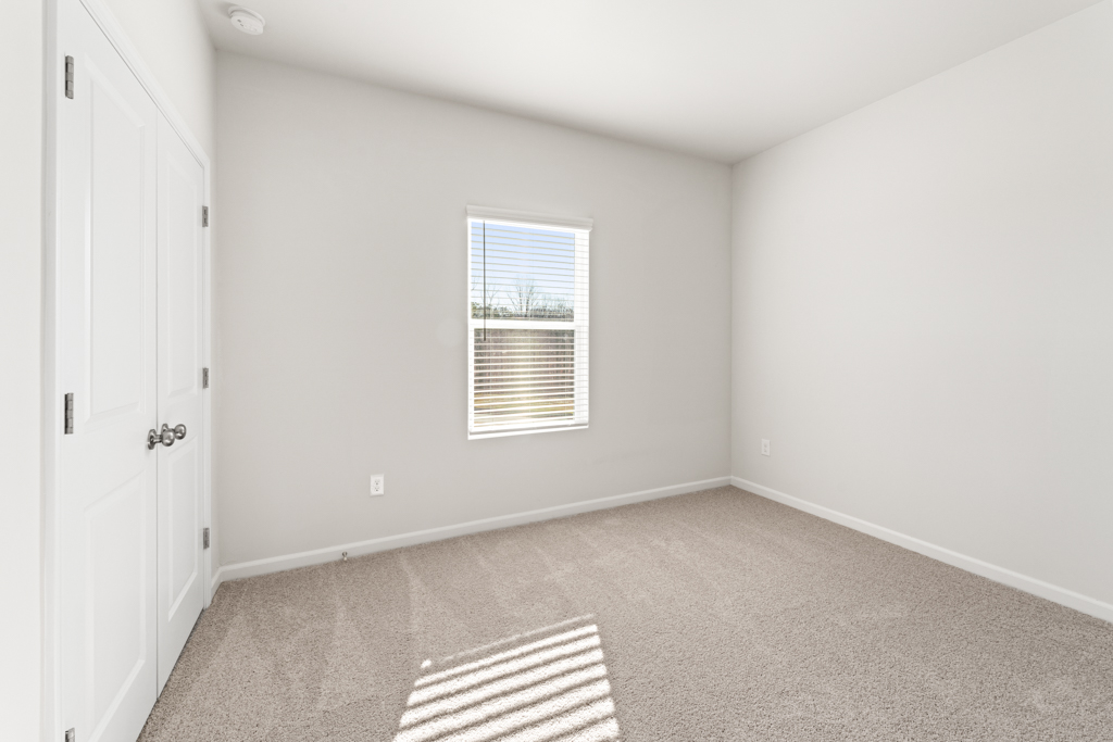 A room with a rug and a window.