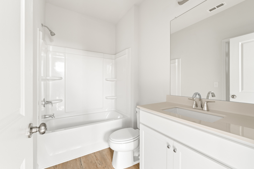 A bathroom with a tub sink and toilet.