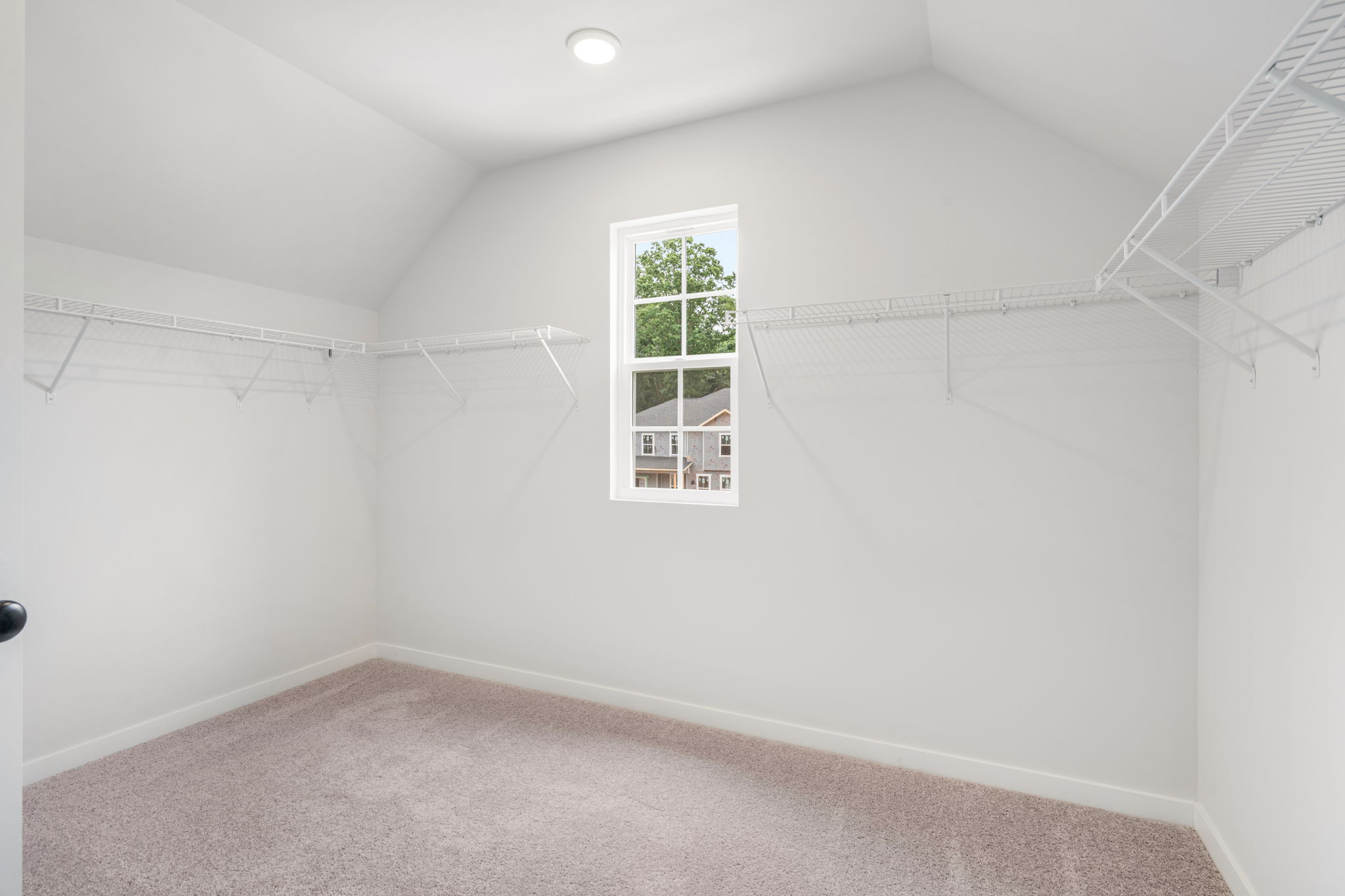 A room with a window and a carpet.