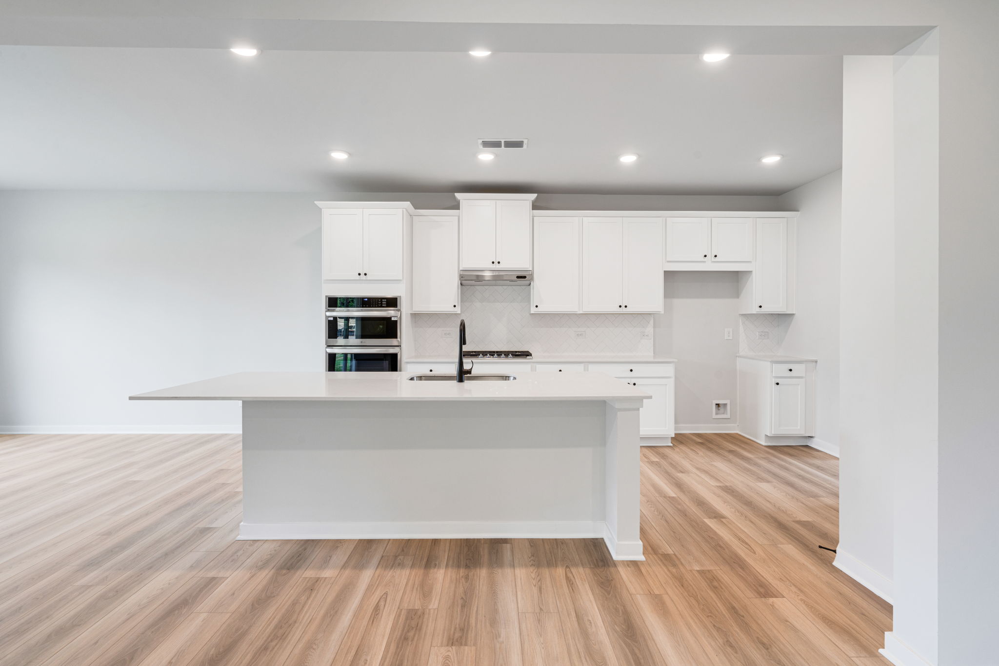 A kitchen with white cabinets.
