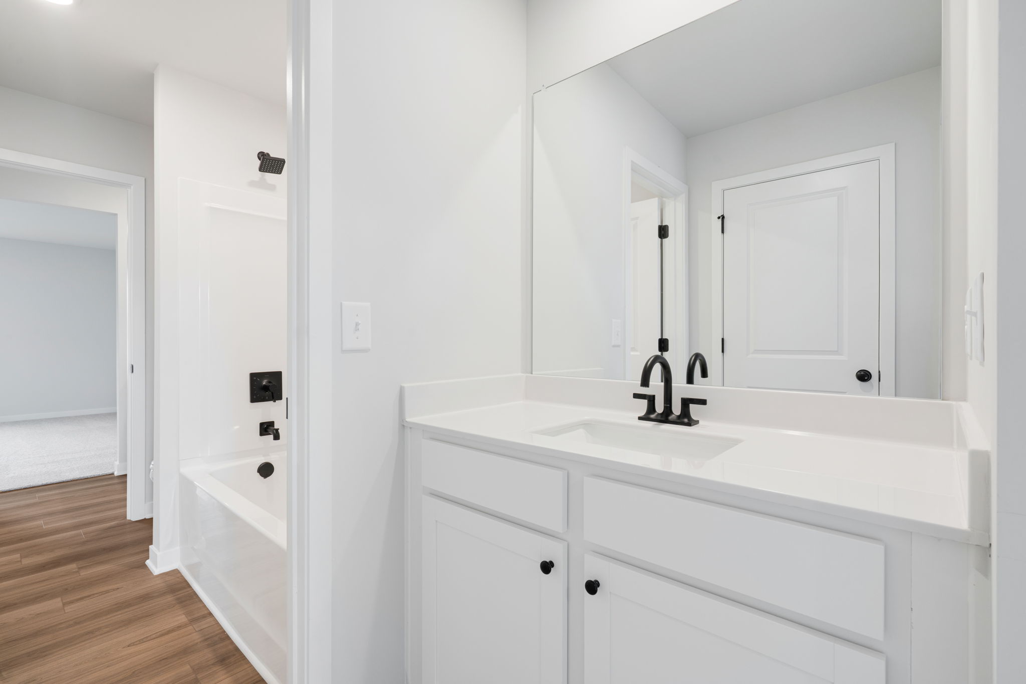A bathroom with white cabinets.