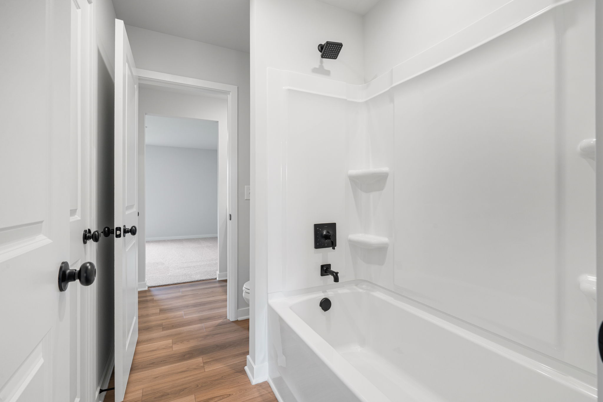 A bathroom with a tub and toilet.