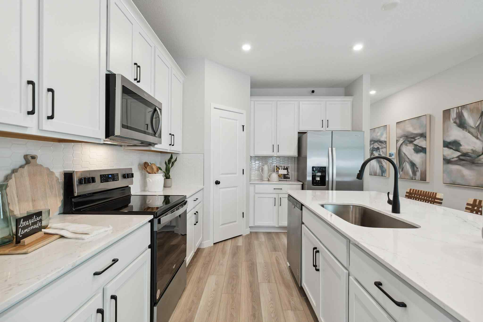 A kitchen with white cabinets.