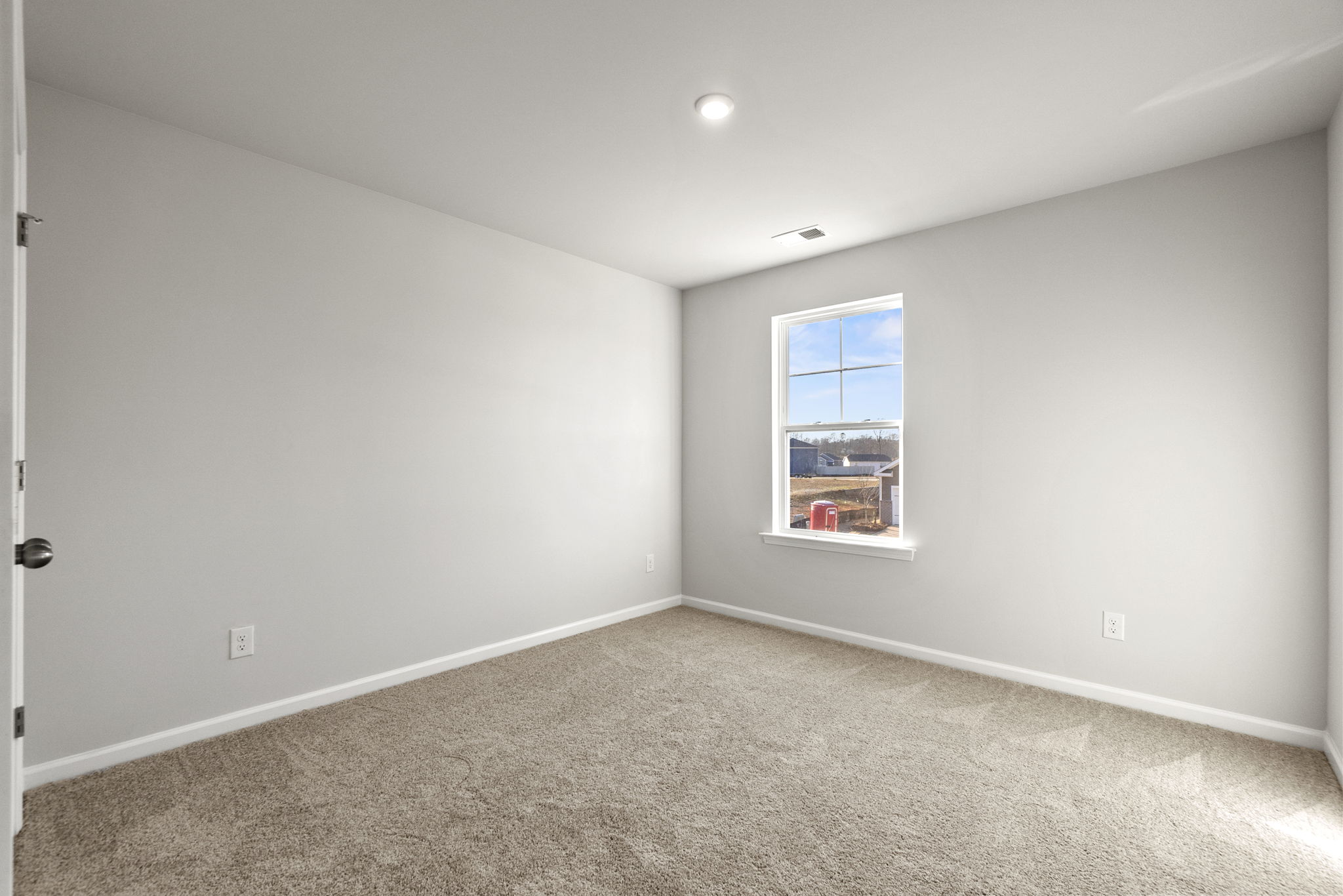 A room with a window and carpet.