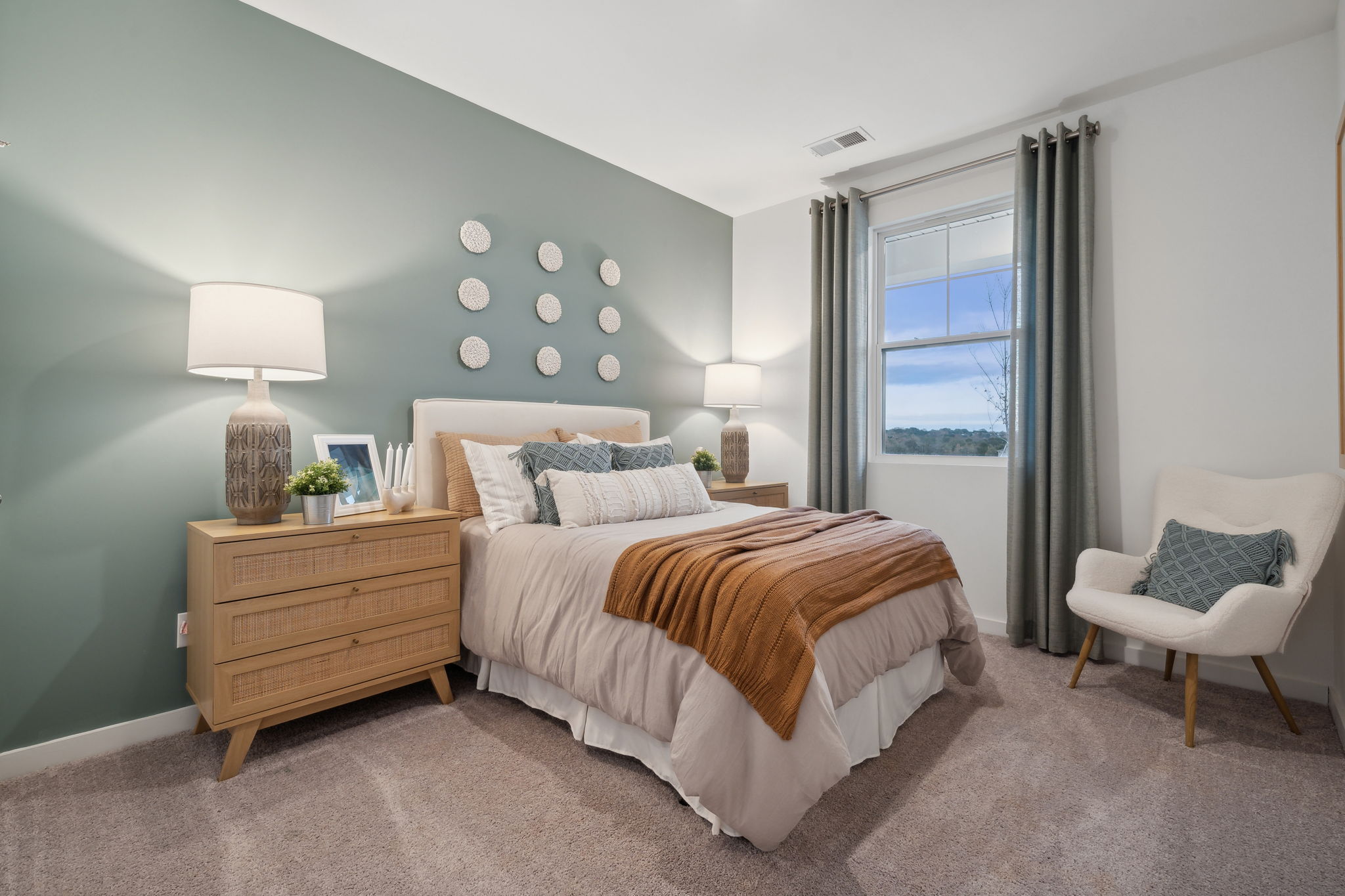 A bedroom with a bed and a chair.