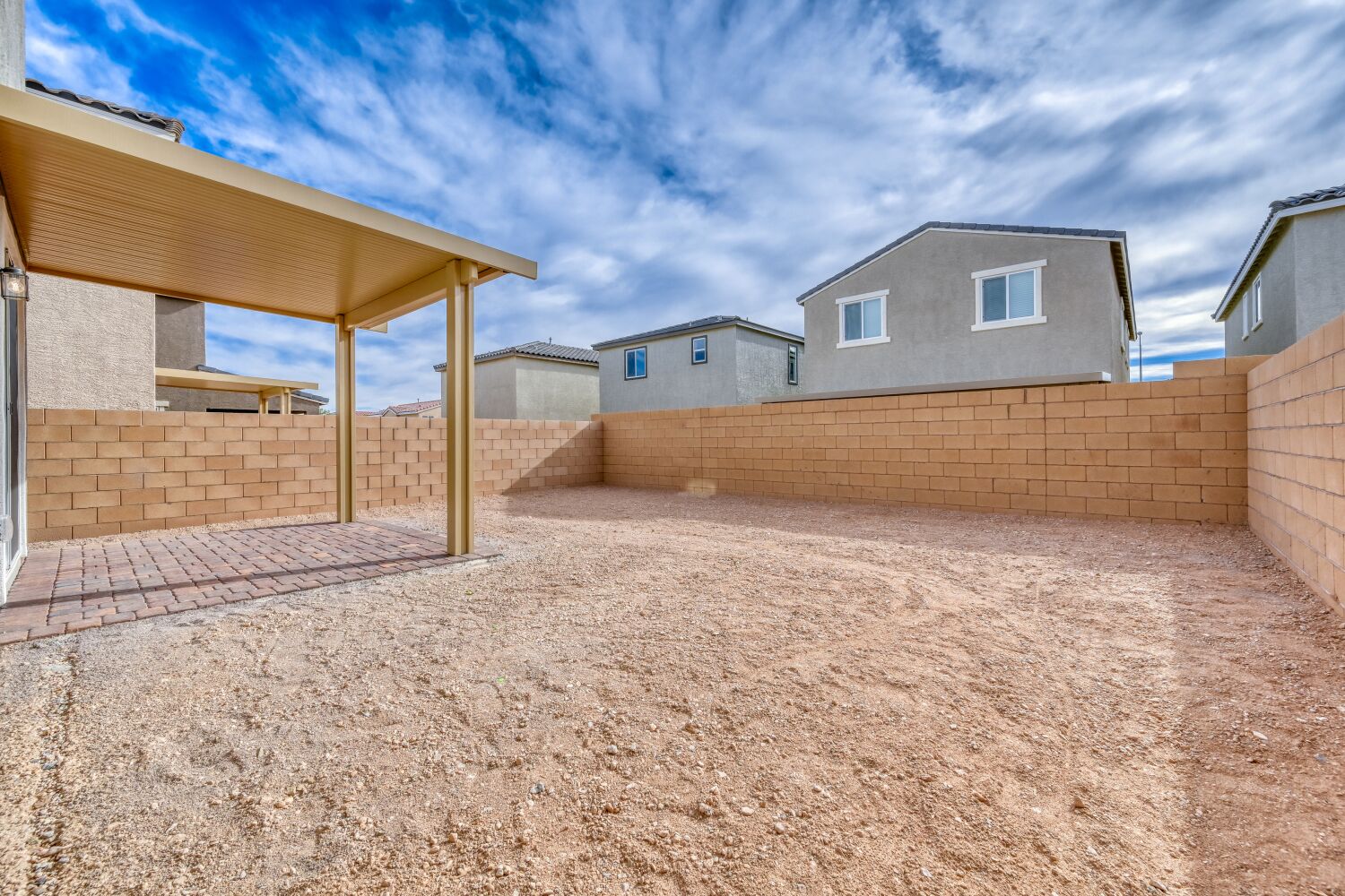 A dirt yard with a building in the background.