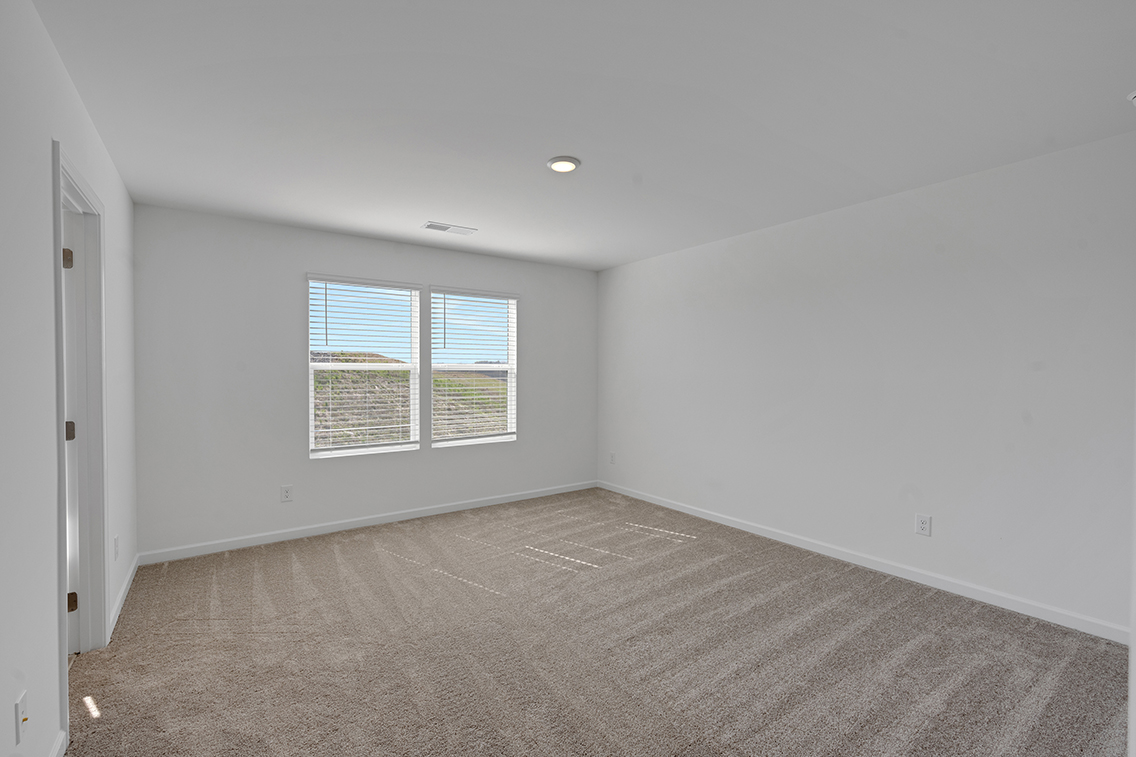 A room with a window and a carpet.