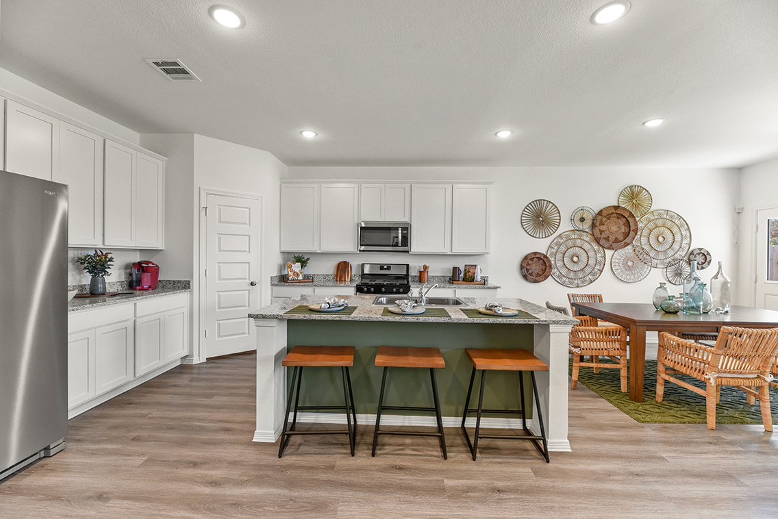 A kitchen with white cabinets and a table with plates on it.