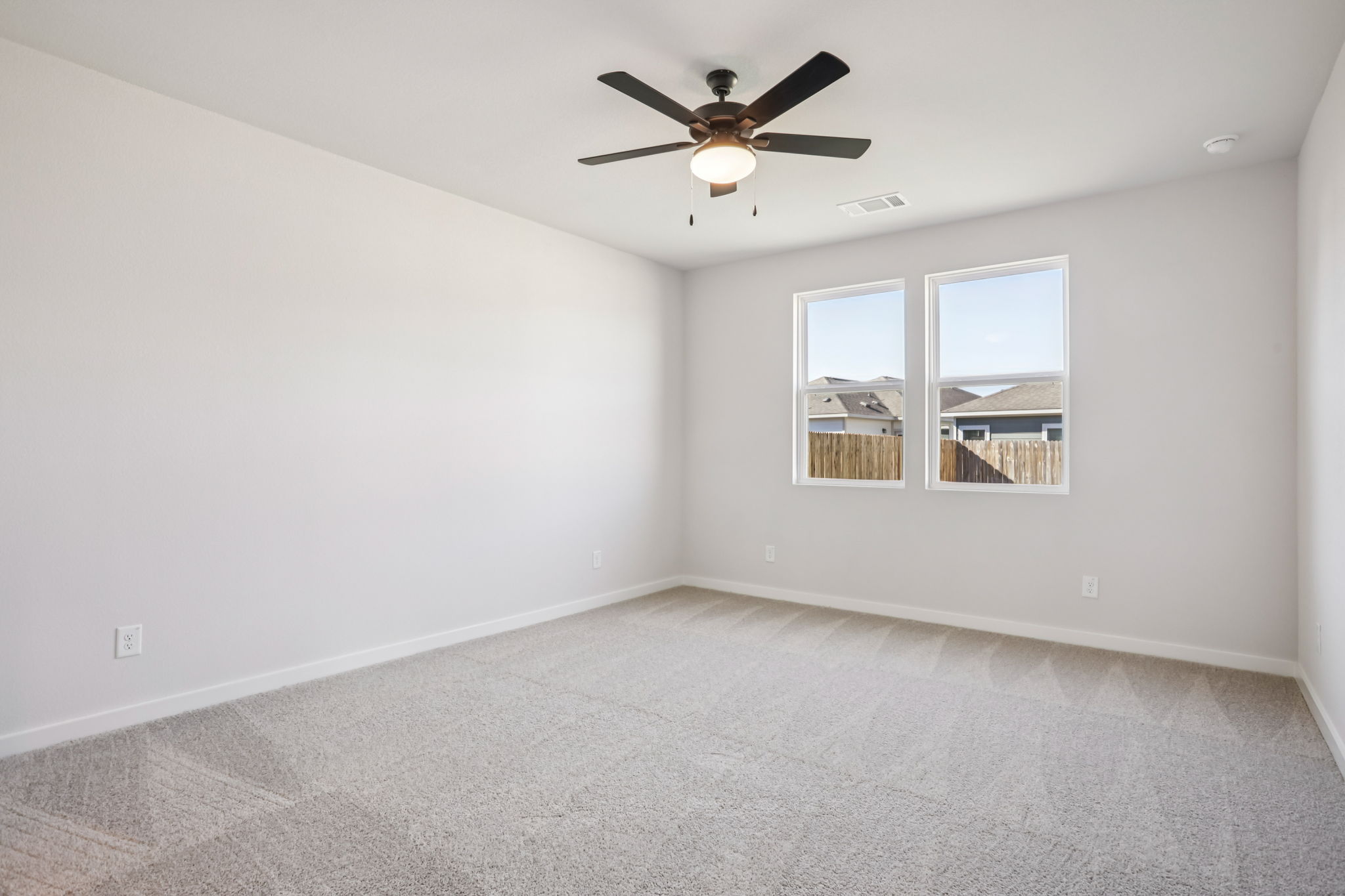 A room with a ceiling fan and a window.