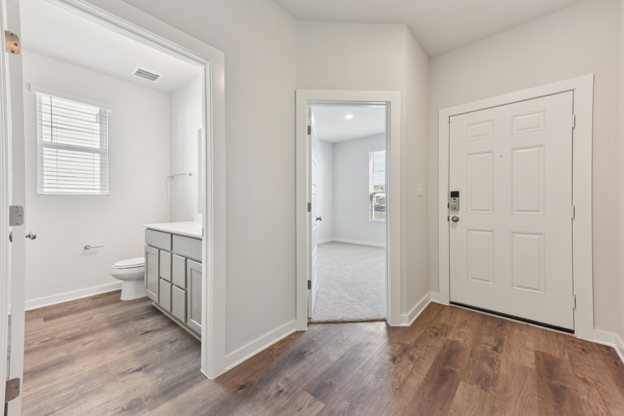 A bathroom with white cabinets.