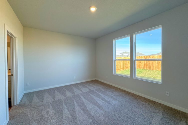 A room with a window and a carpet.