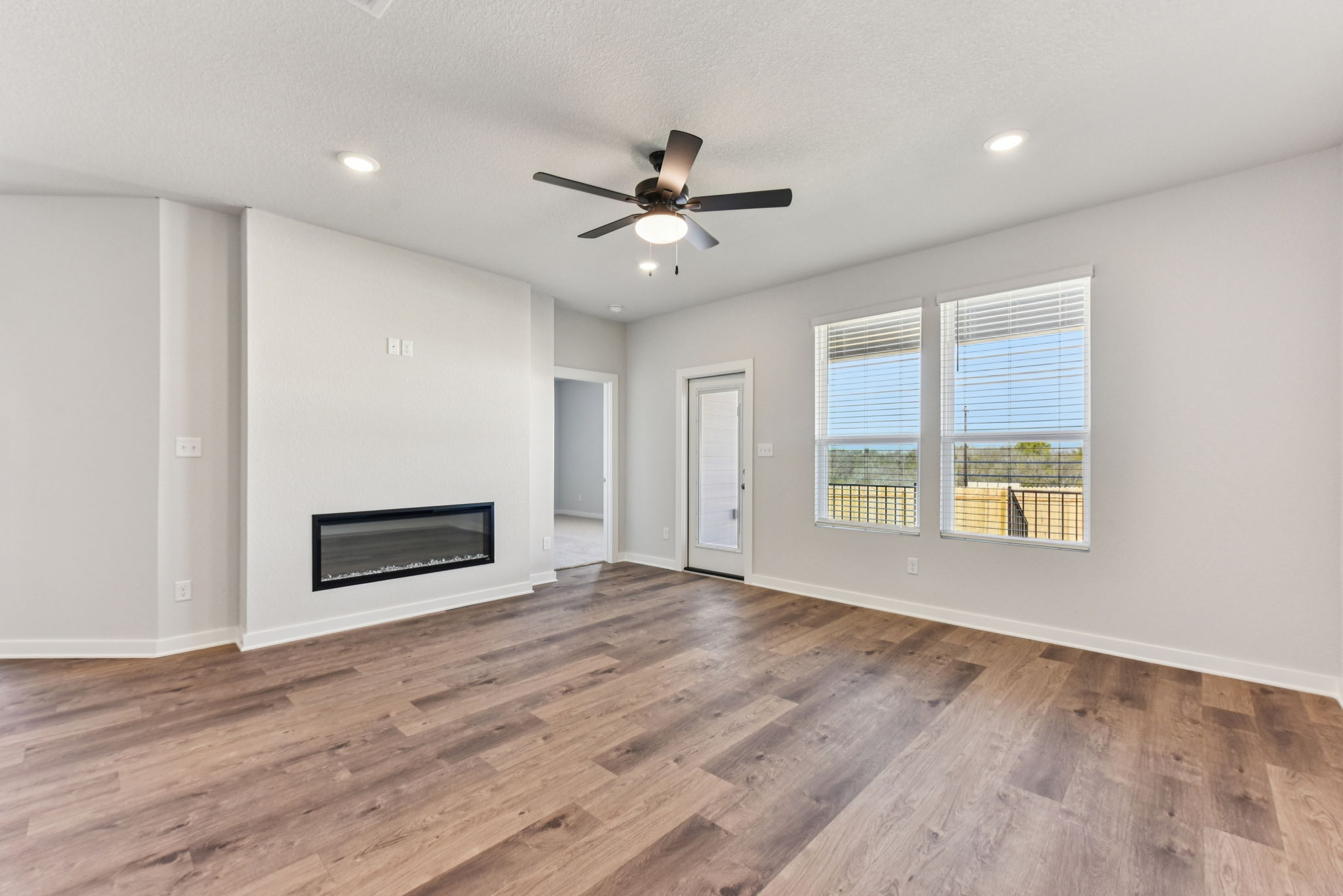 A room with a wood floor and a ceiling fan.