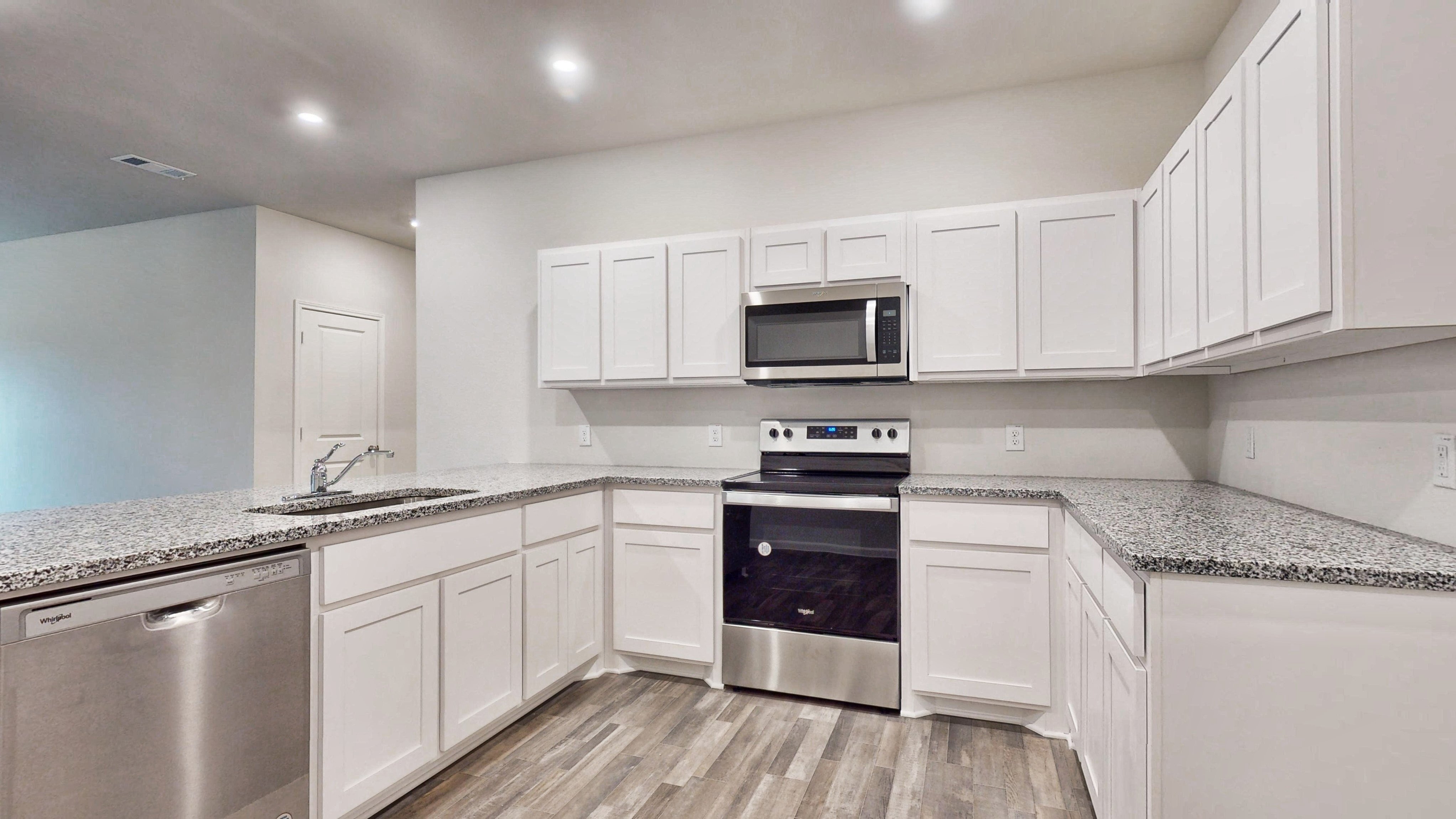 A kitchen with white cabinets.
