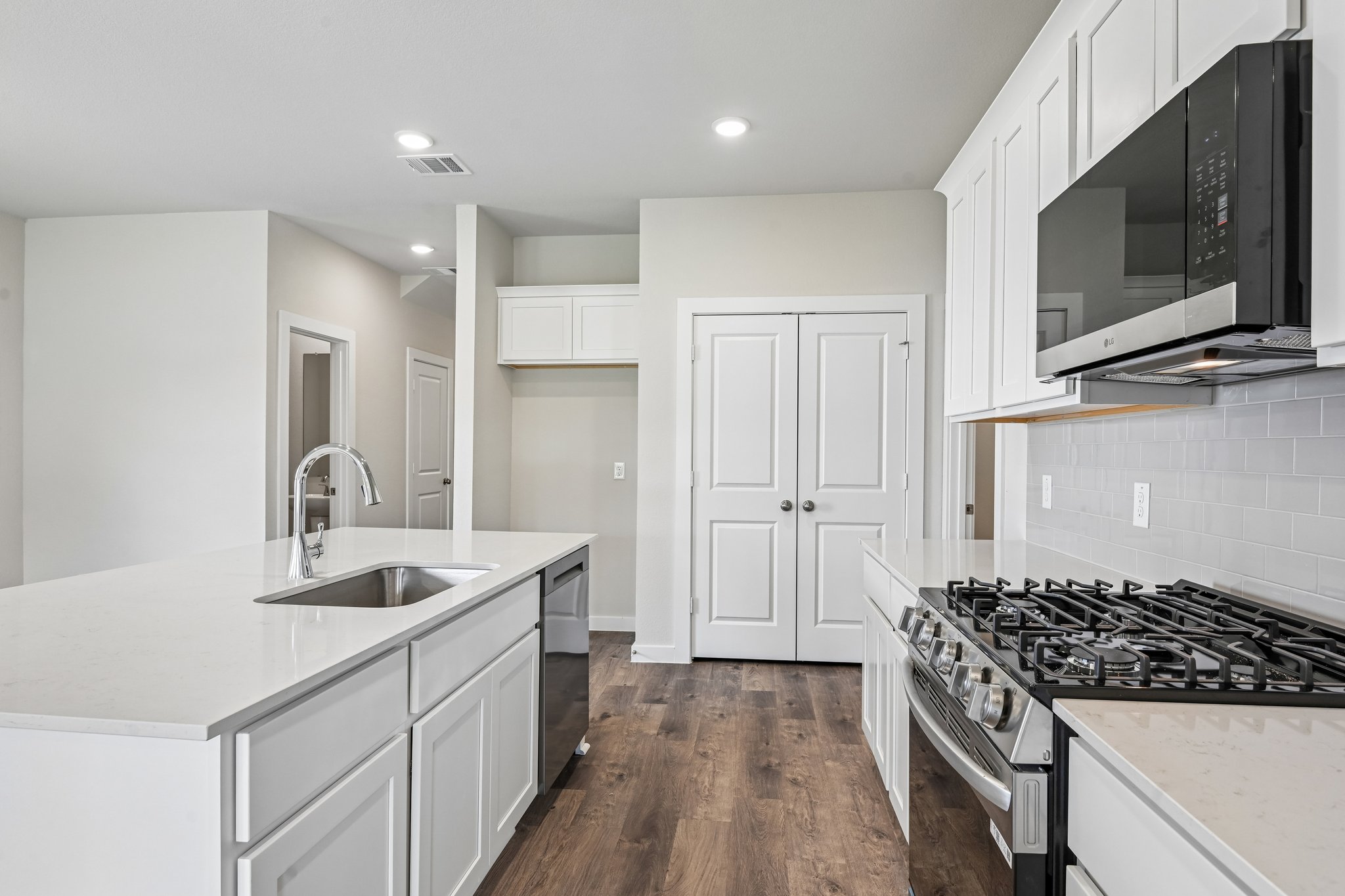 A kitchen with white cabinets.