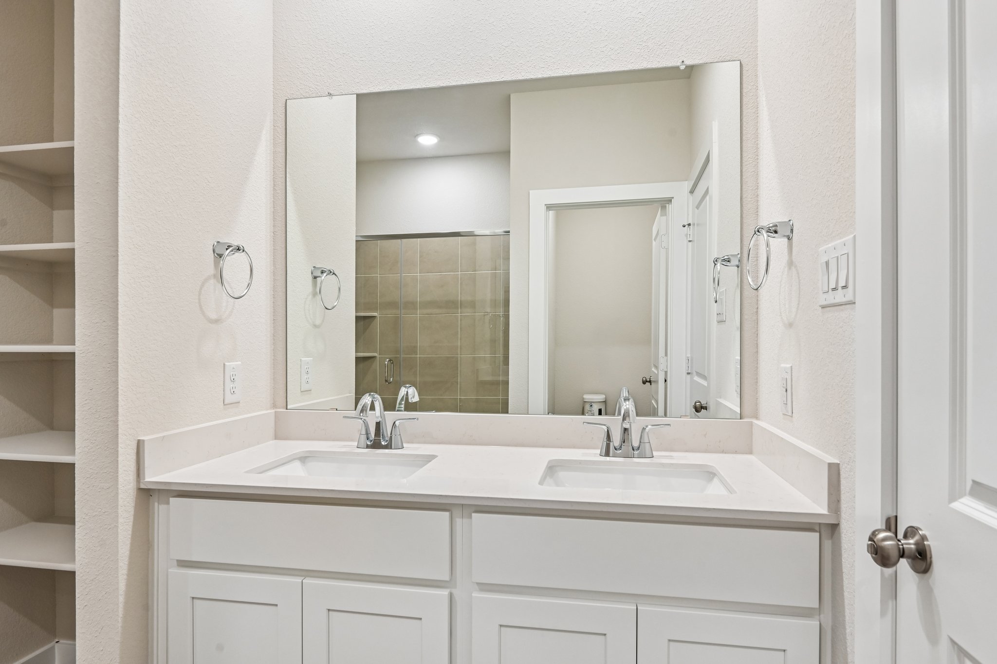A bathroom with a large mirror.