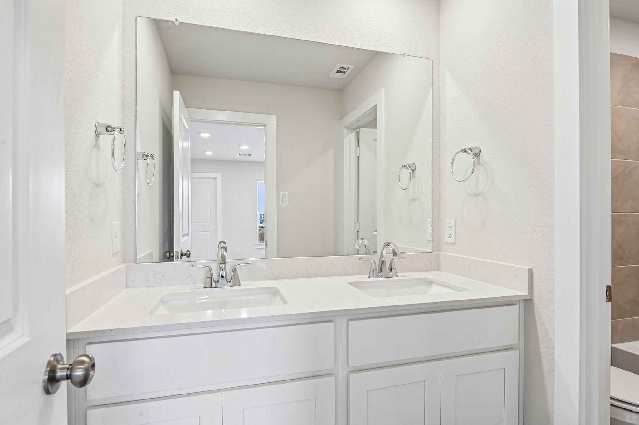 A bathroom with a large mirror.