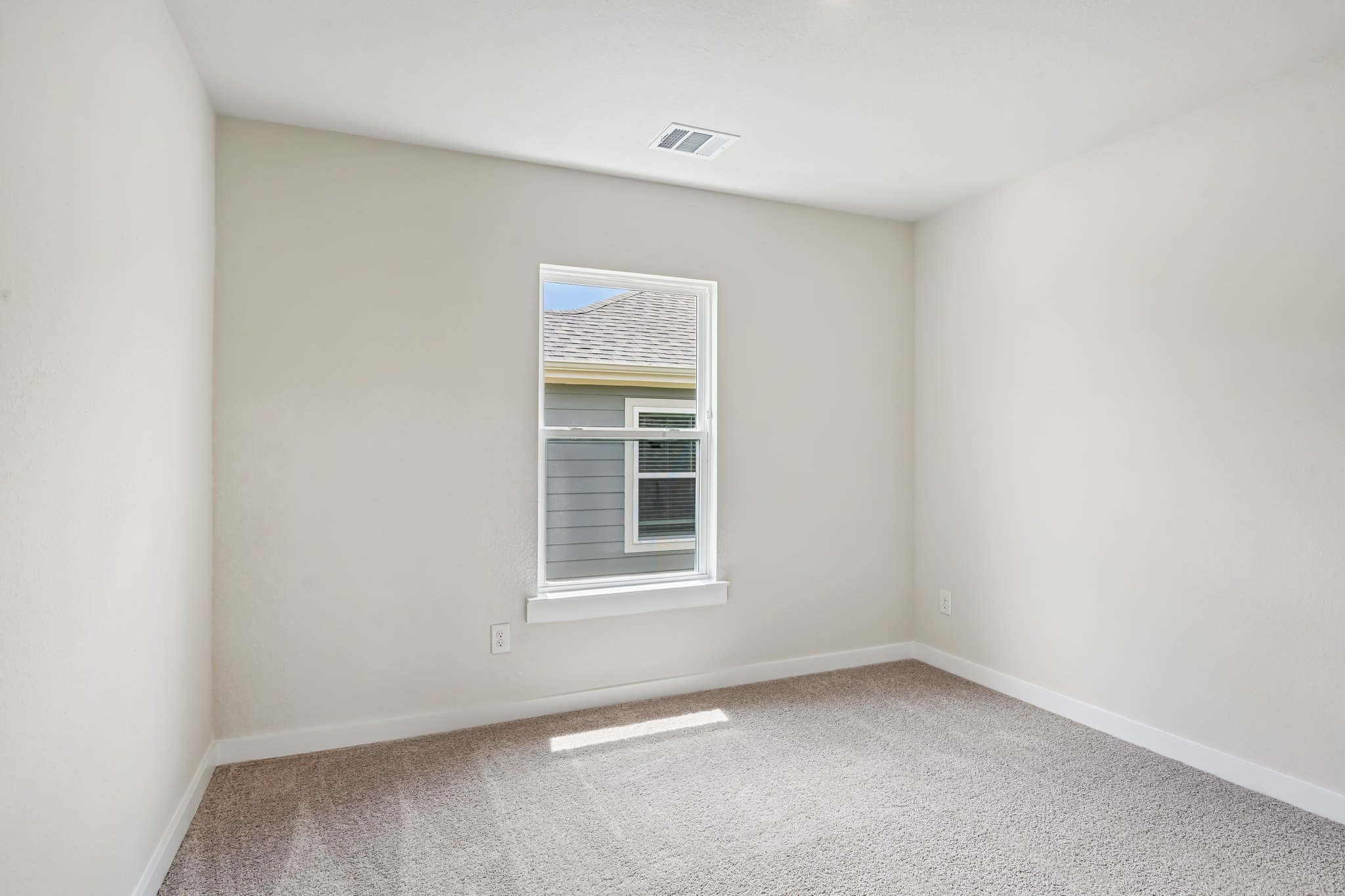 A room with a window and carpet.