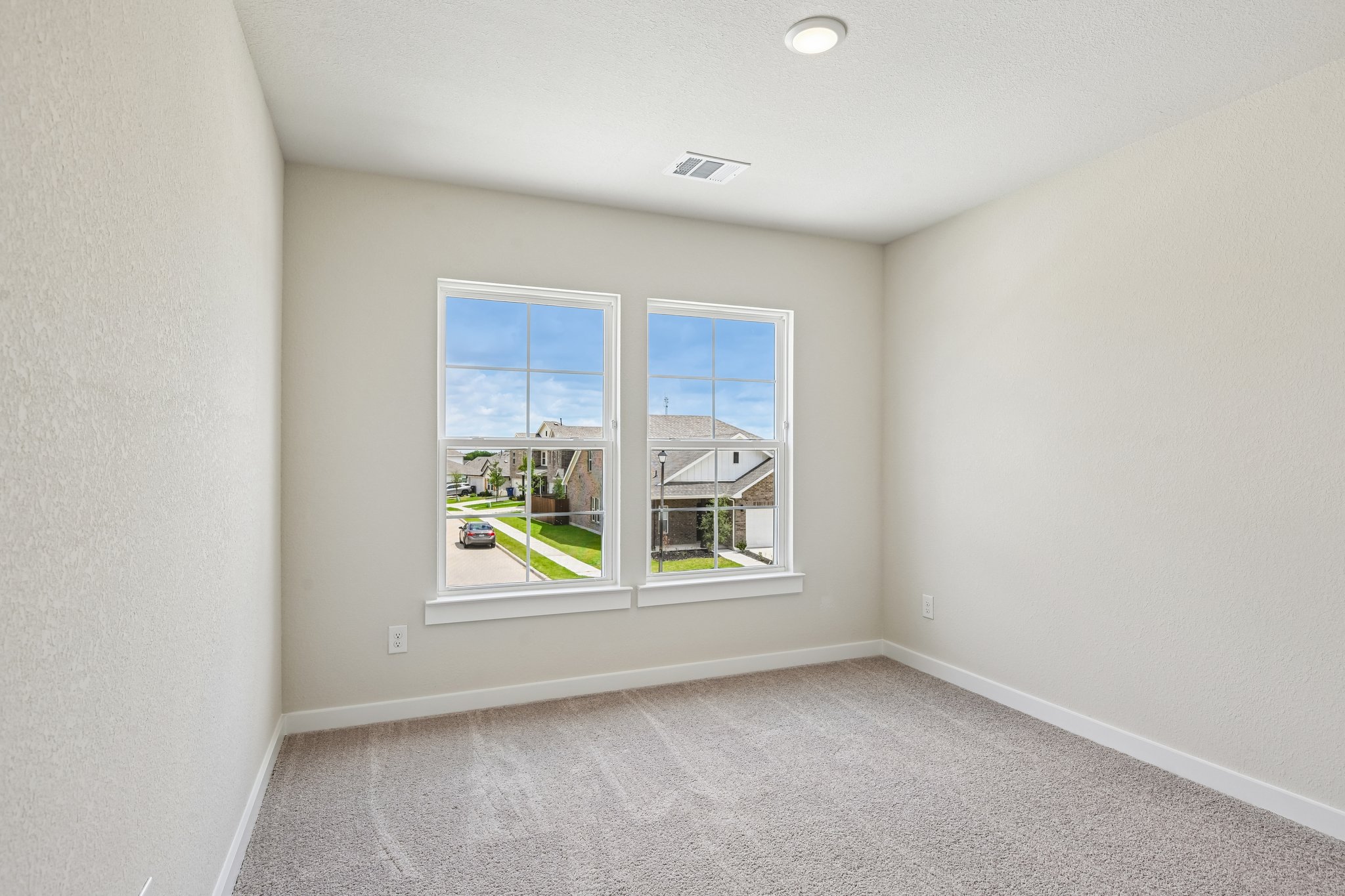 A room with a window and a carpet.