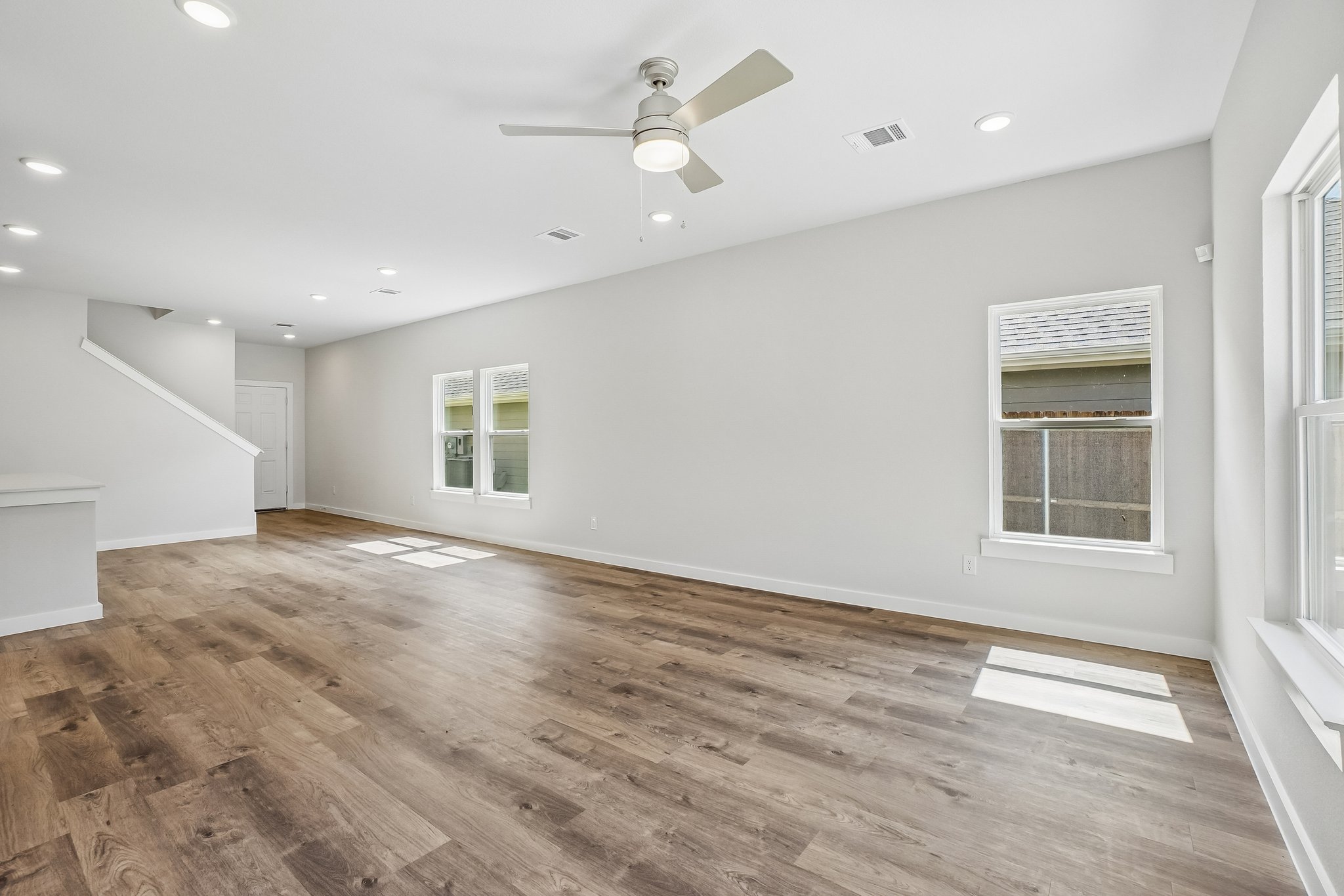 A room with a wood floor and a ceiling fan.