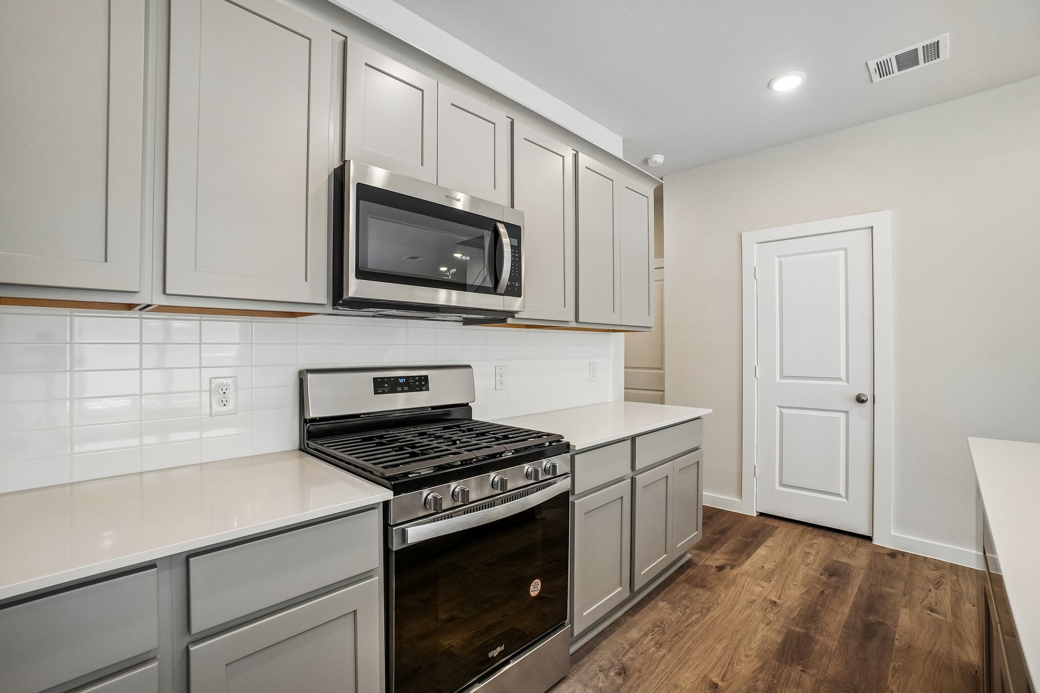 A kitchen with white cabinets.