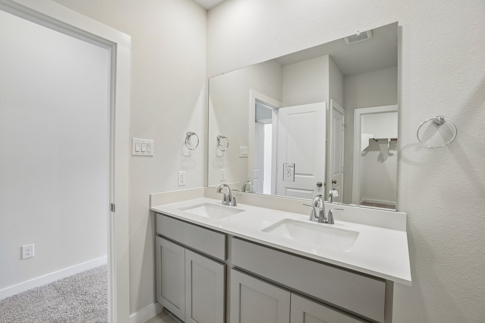 A bathroom with a large mirror.