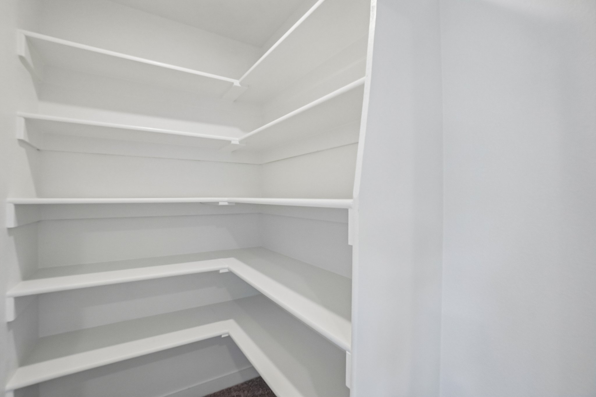 A white shelf with white walls.